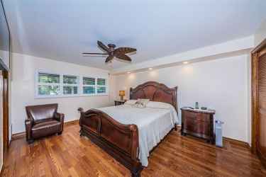 Master Bedroom with plantation shutters, custom ceiling fan, laminate flooring and hurricane windows