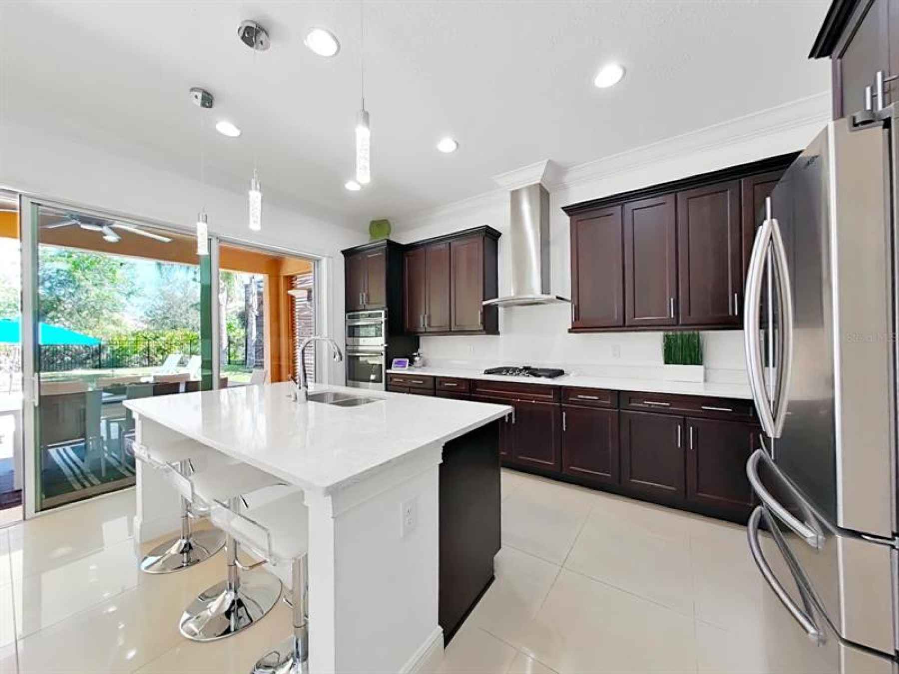 Modern kitchen with Quartz, pendant lights, natural gas cooktop, stainless steel range hood and Fren
