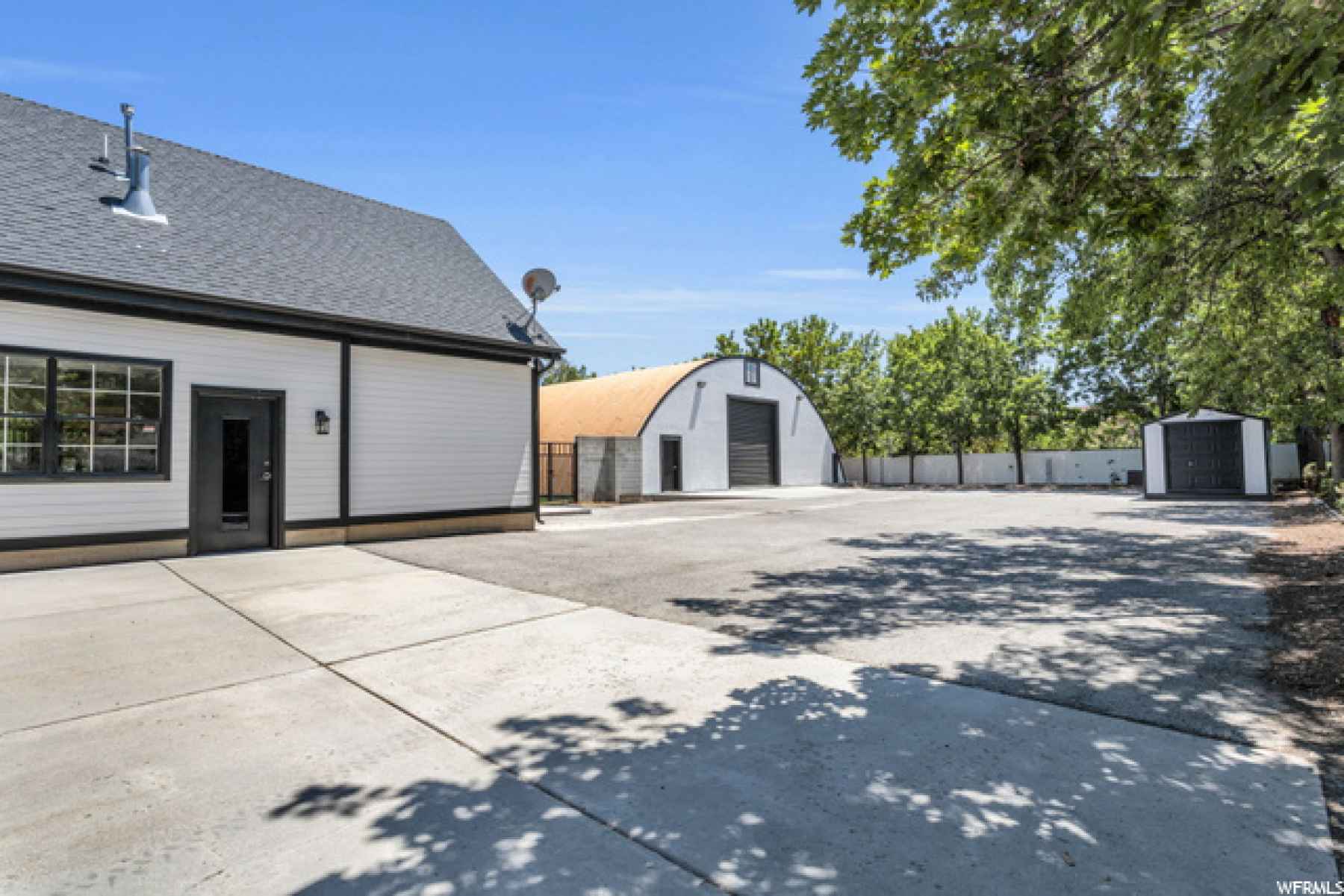 Here you can see the side apartment entrance, the quonset, and between is an entrance to back yard through wrought iron gates. Also views of large, additional storage shed.
