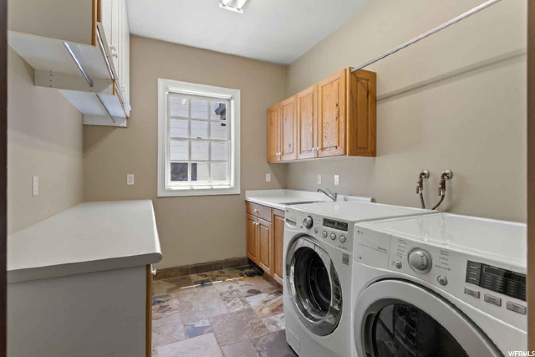 You might just enjoy doing laundry! Here you have a view of the backyard, plenty of storage cabinets and folding areas, built in ironing board!