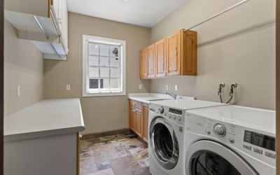 You might just enjoy doing laundry! Here you have a view of the backyard, plenty of storage cabinets and folding areas, built in ironing board!