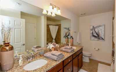 guest bathroom with dual sinks and tub shower combo
