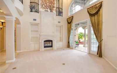 Gorgeous expansive living room with stone fireplace; opens to pool, golf course and lanai