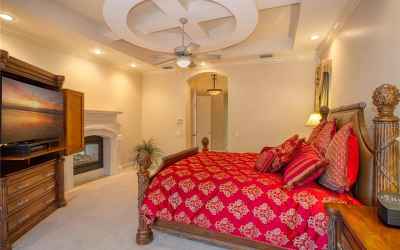 Master suite with detailed ceiling and fireplace