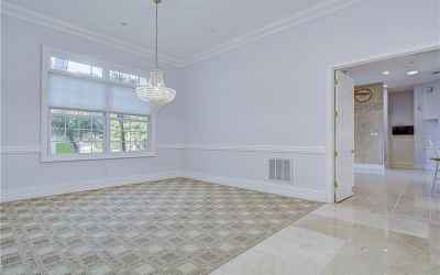 Beautiful chandelier hanging in this open floor plan with neutral colored walls!