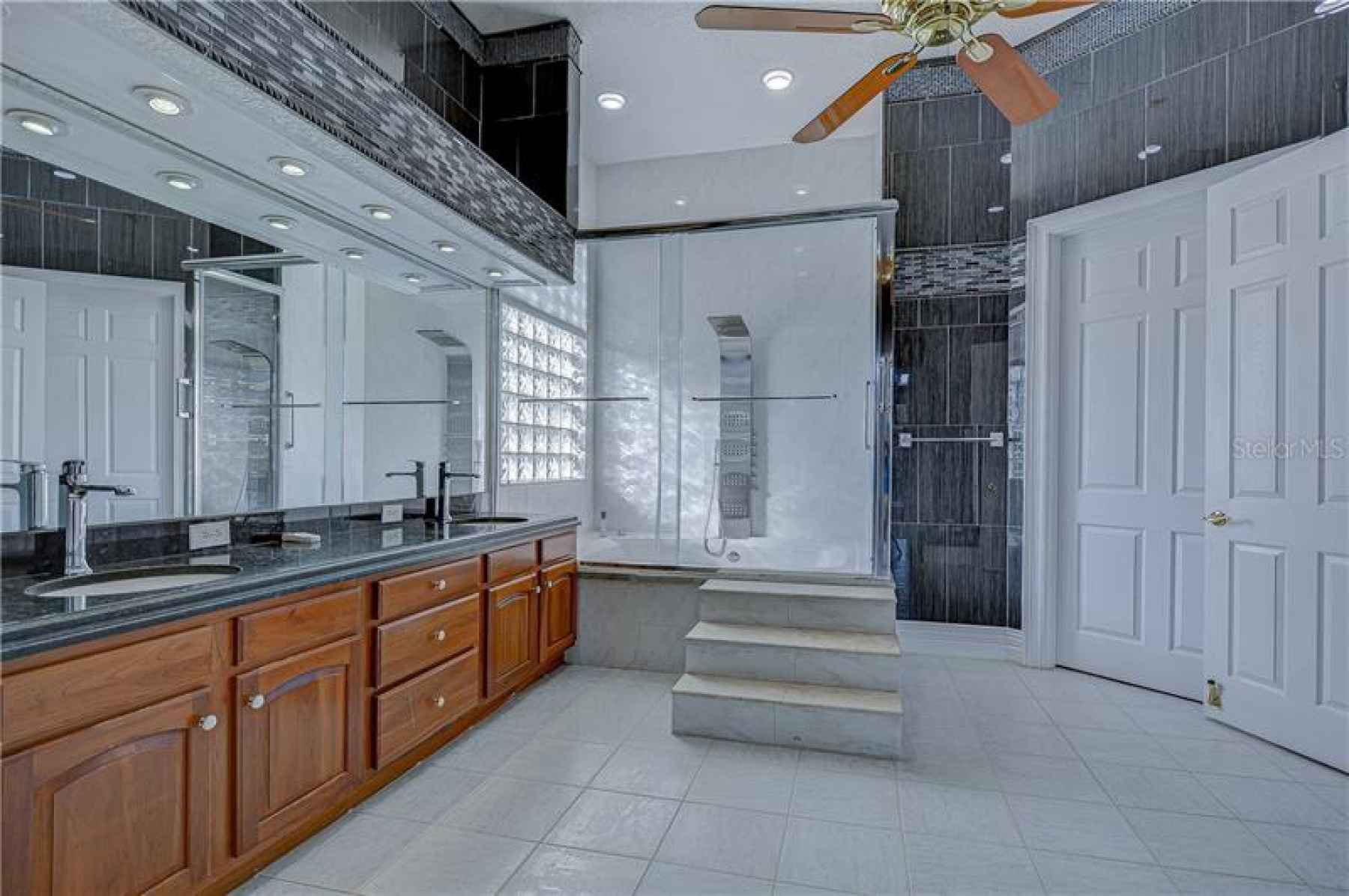 This master bath features his and her sinks as well as STEPS leading up to the walk in shower!