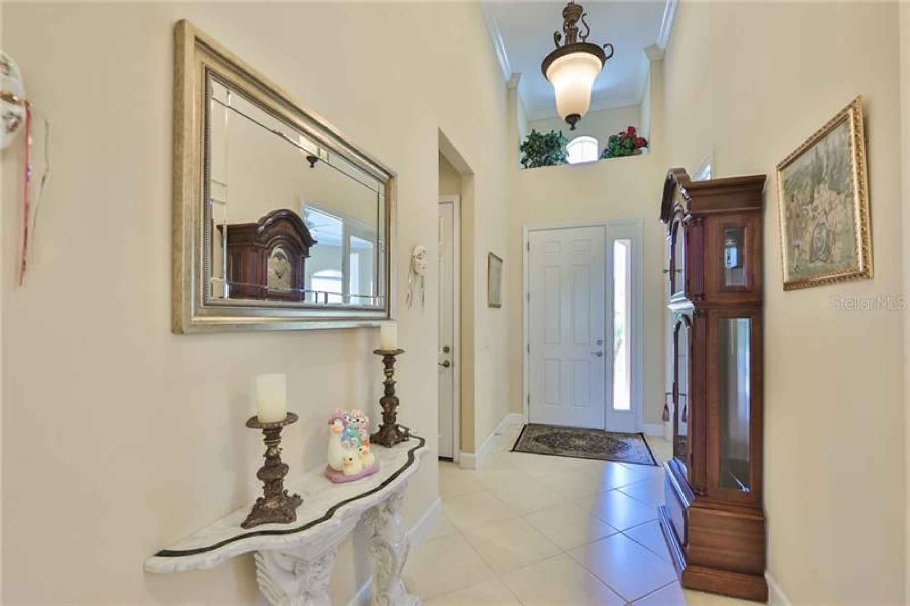 Front foyer is wide, bright and inviting with handsome light fixtures and crown molding.