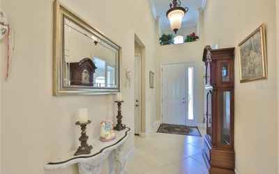 Front foyer is wide, bright and inviting with handsome light fixtures and crown molding.