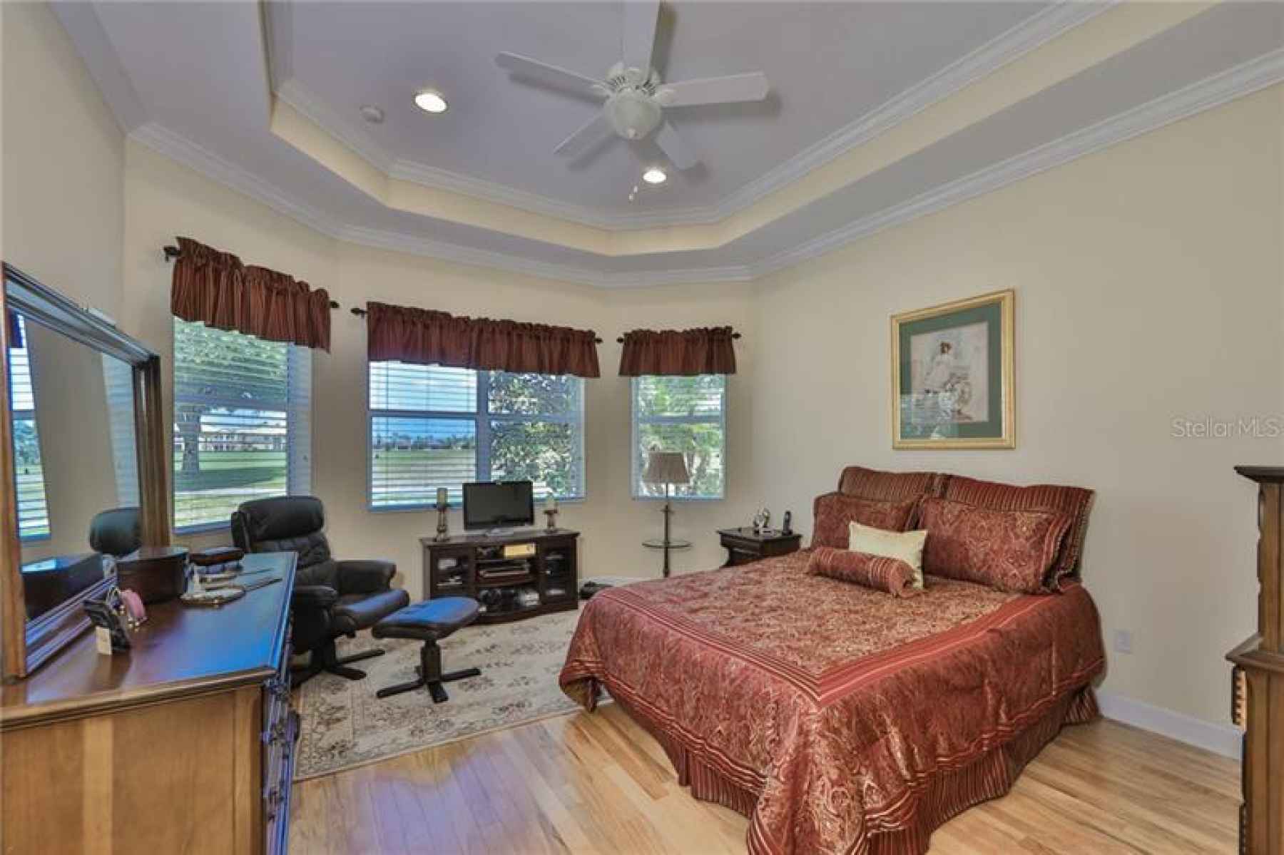 The bedroom is sumptious with the tray ceiling, crown molding, laminate flooring and large windows!