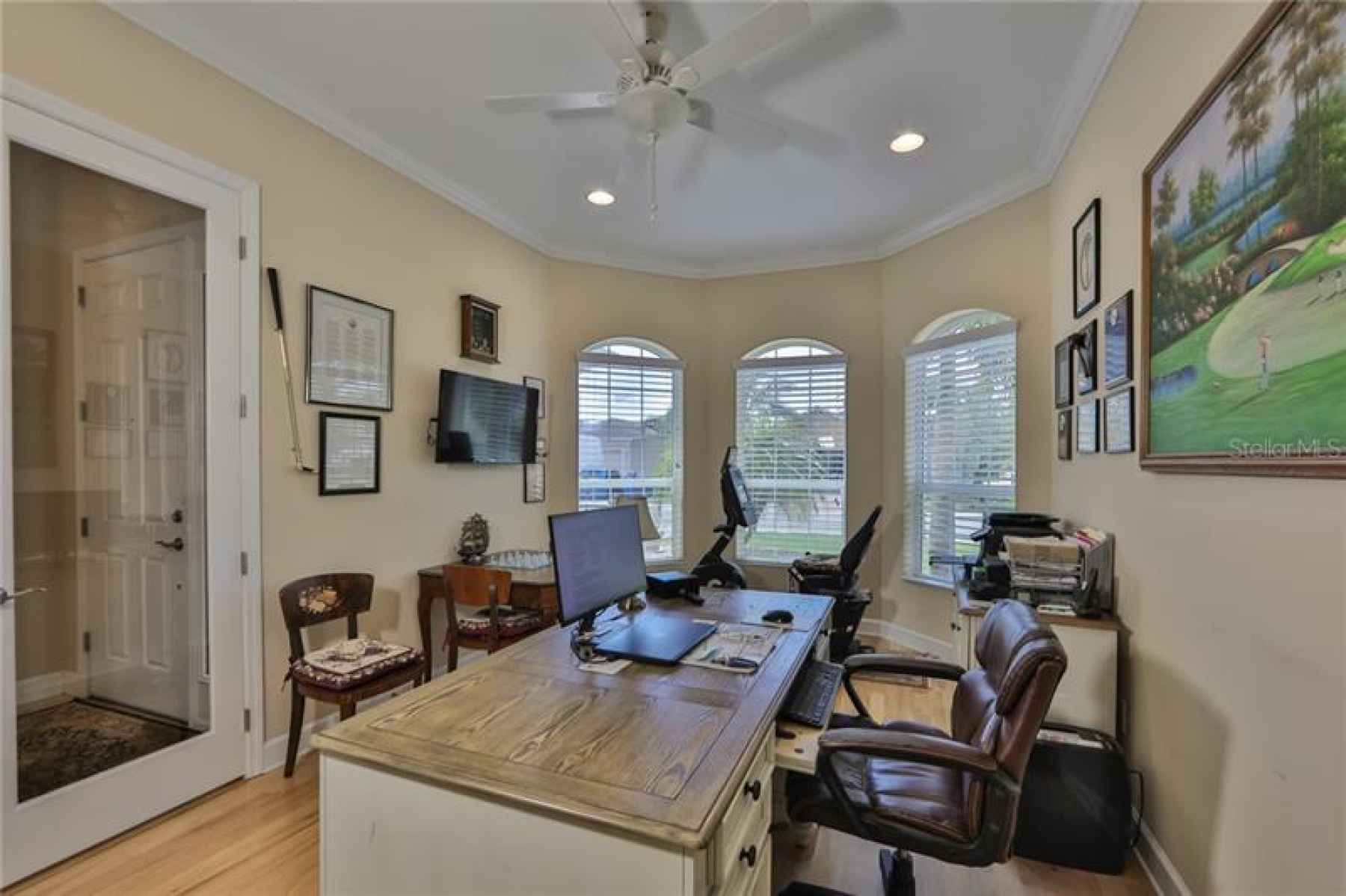 What an office!  Large glass french doors, crown molding and large windows make this space enjoyable