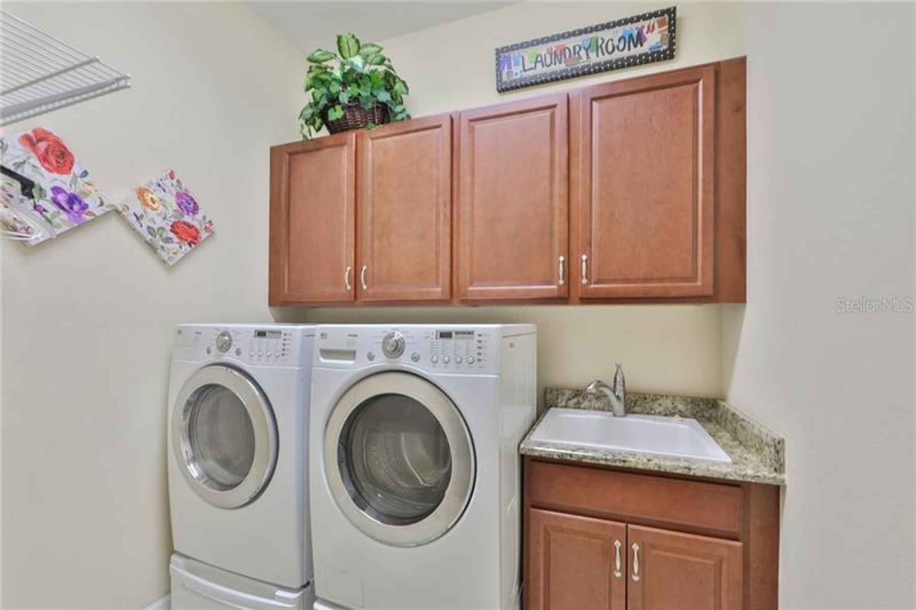 The laundry room is good size, with shelving, cabinetry and a granite countered utility sink.