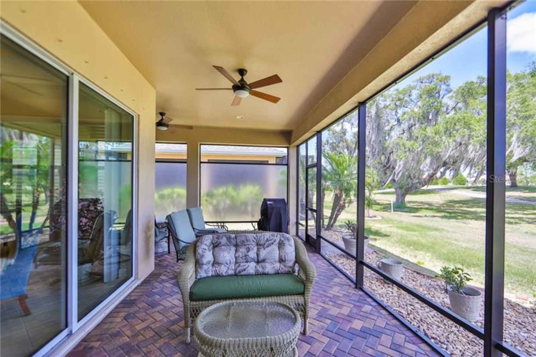 Large L-Shaped, screened lanai with permanent privacy screens and nothing but an expanse of green!