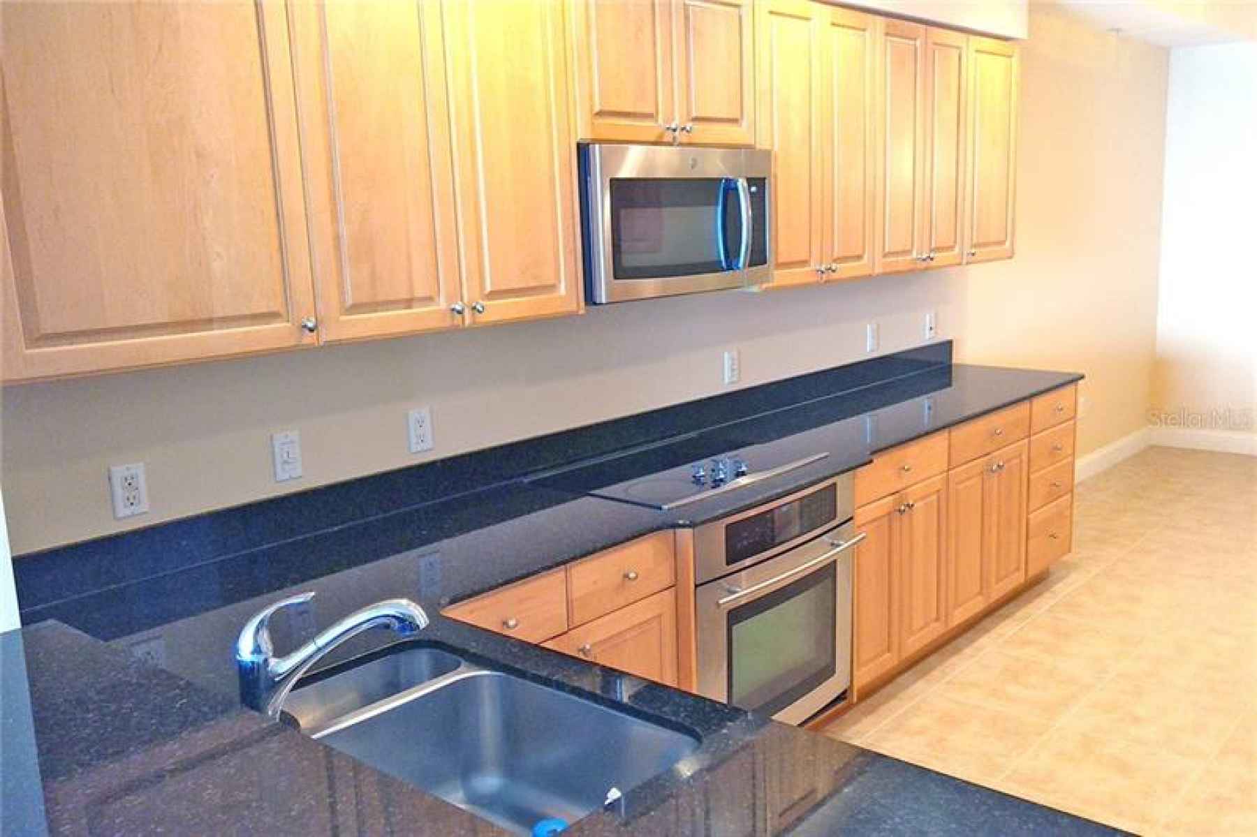 Kitchen with granite countertops, maple cabinetry, stainless undermount sink and stainless appliance