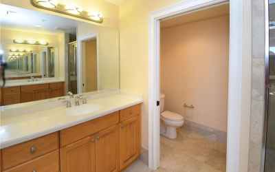 Master bath with dual vanities with Corian countertops, and water closet.
