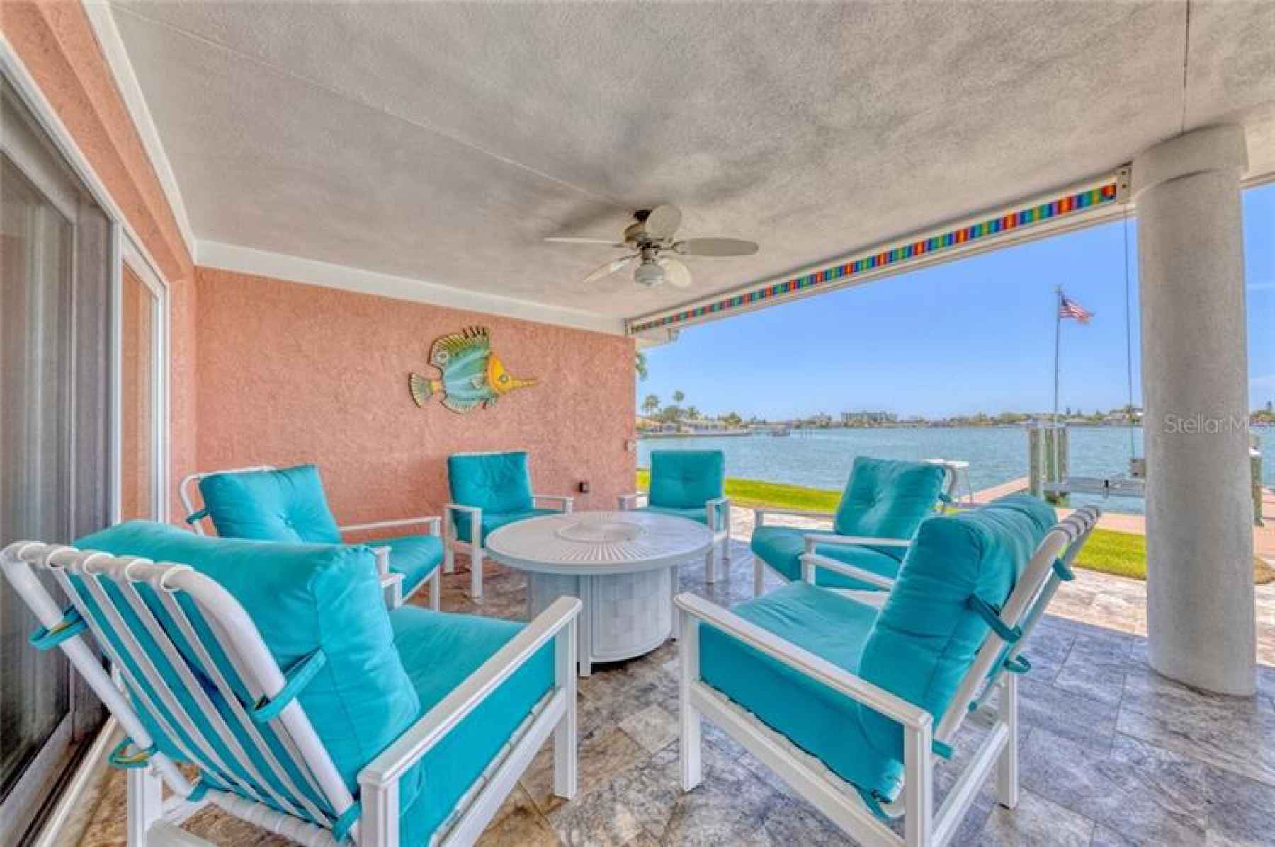 Covered entertainment lanai with a colorful pull-down shade.
