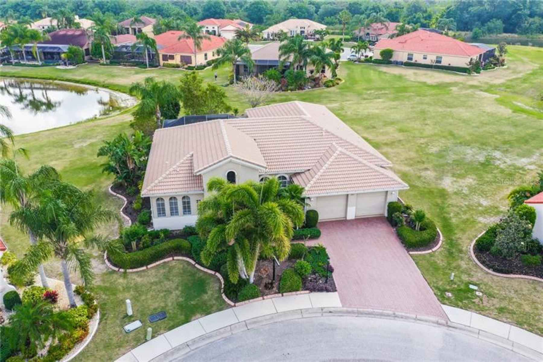 Water view, executive style home with custom brick paved driveway, tile roof and stunning landscape,