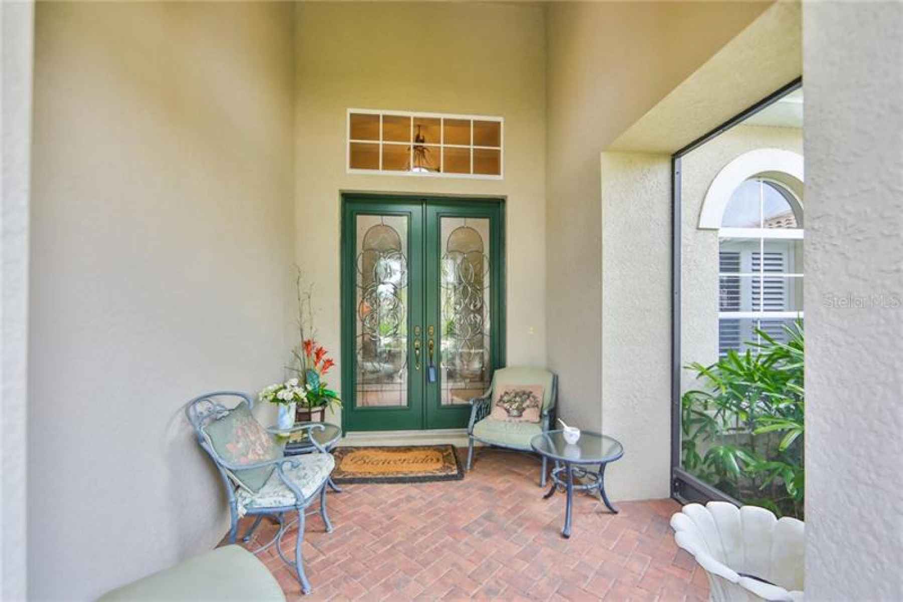 Beautifully covered front entrance, brick pavers and high ceilings with lovely lead glass doors to w
