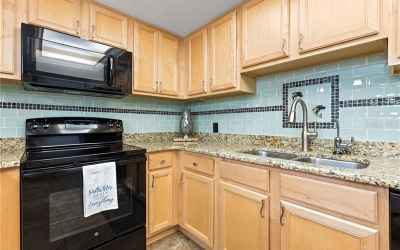 Kitchen featuring granite counter tops, solid wood cabinetry and custom coastal back splash.