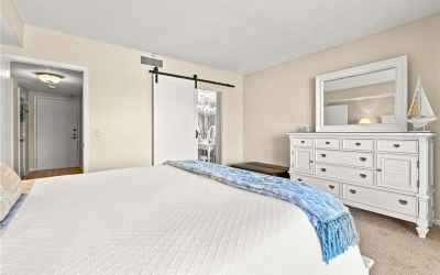 Master suite featuring beach views, sliding barn door, walk in closet, separate vanity area.