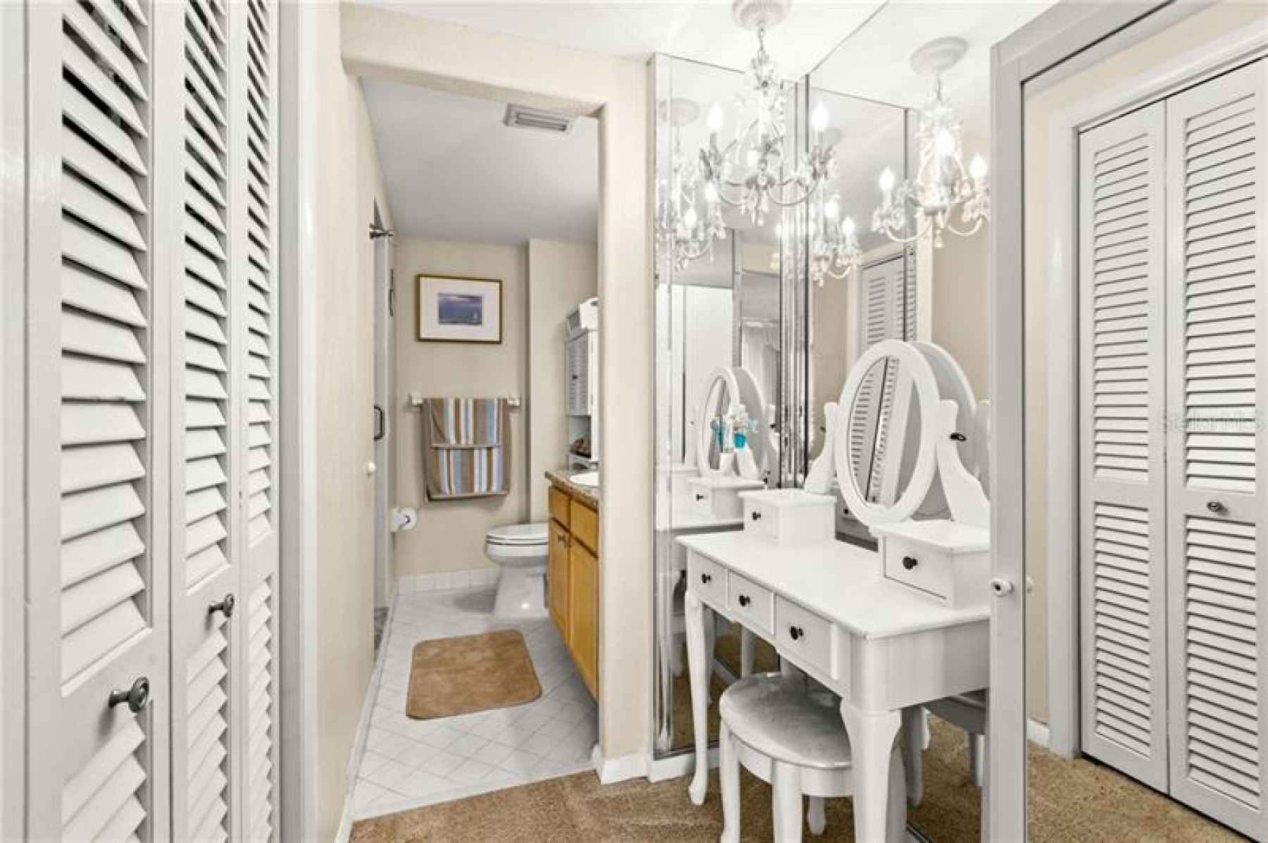 Master vanity area, walk in closet and bathroom with step in shower.