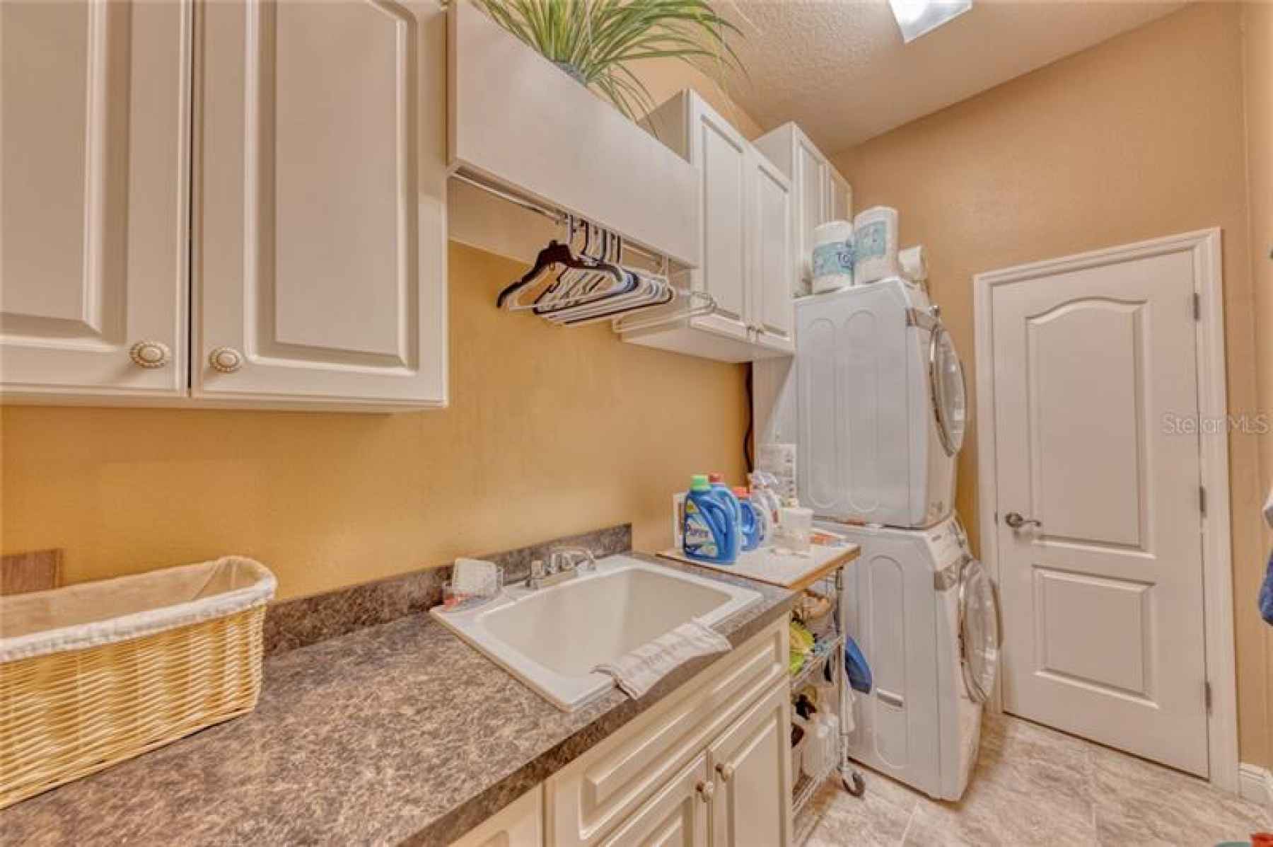 Laundry room with ample cabinet storage and large storage closet