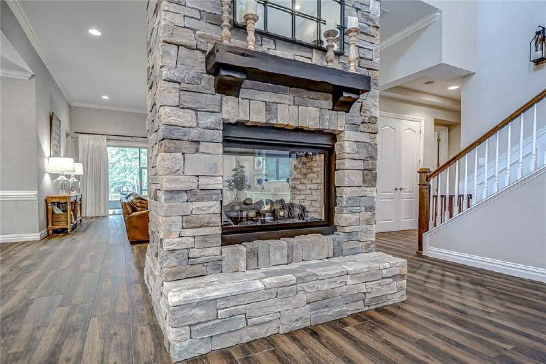 Move into the atrium and notice the statement double-sided gas fireplace with floor-to-ceiling stack
