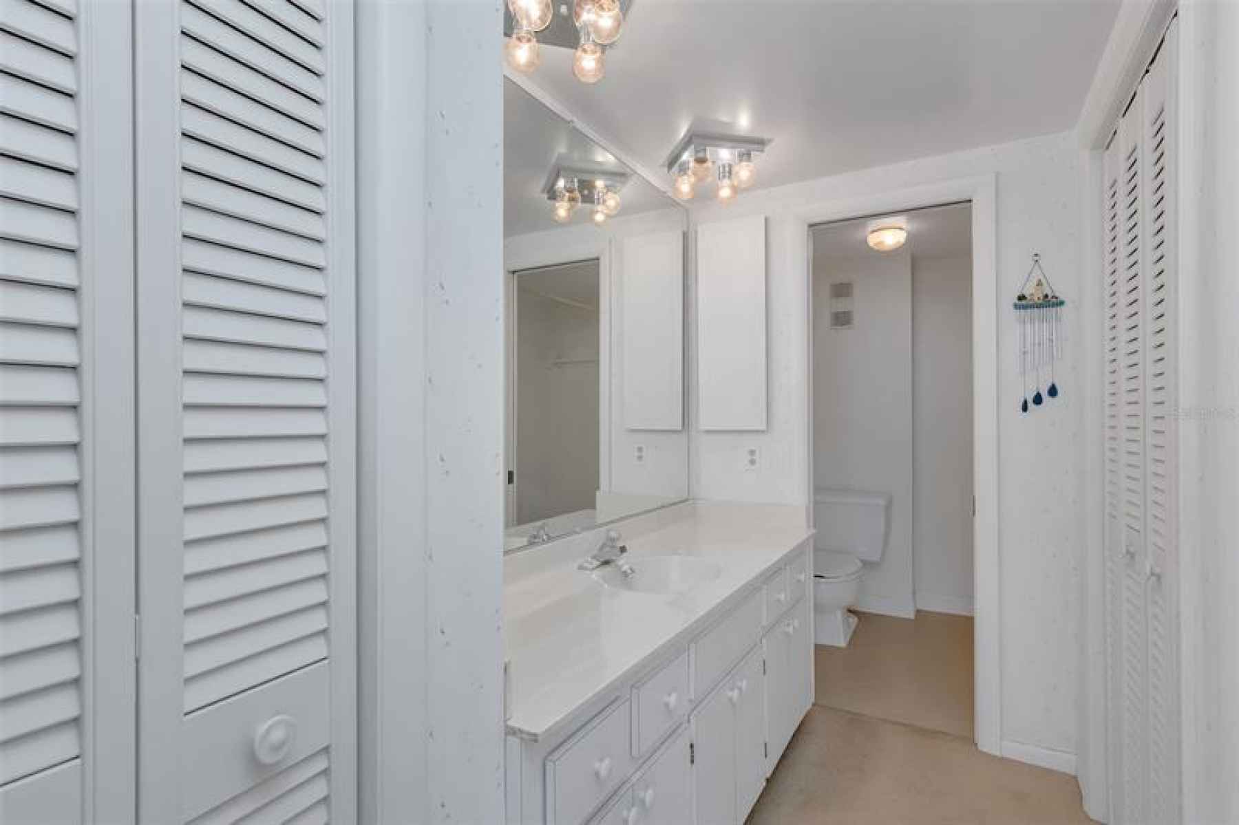 In the east bedroom, the en suite bath with spacious vanity area and multiple closets