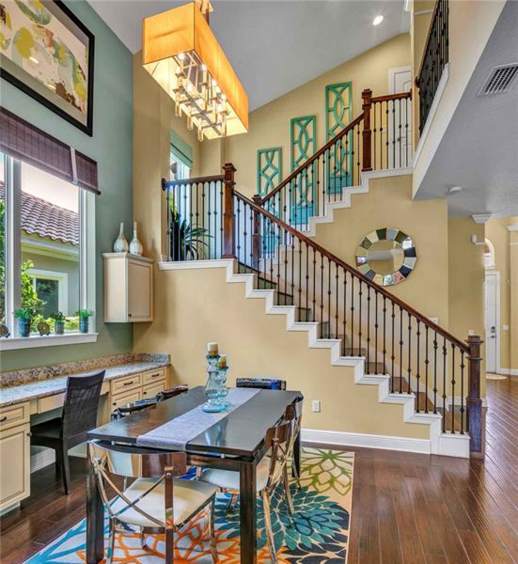 Breakfast Nook view of the grand staircase with a smooth wood finish and rod iron banister leading t