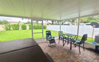 Covered & screened patio with brick/stone flooring