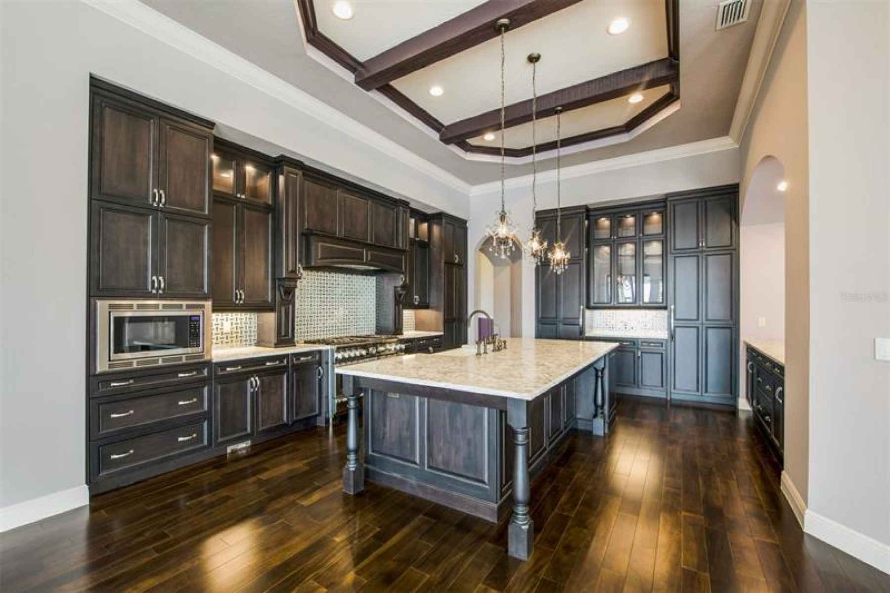Spacious kitchen with quartz counters and tiled backsplash