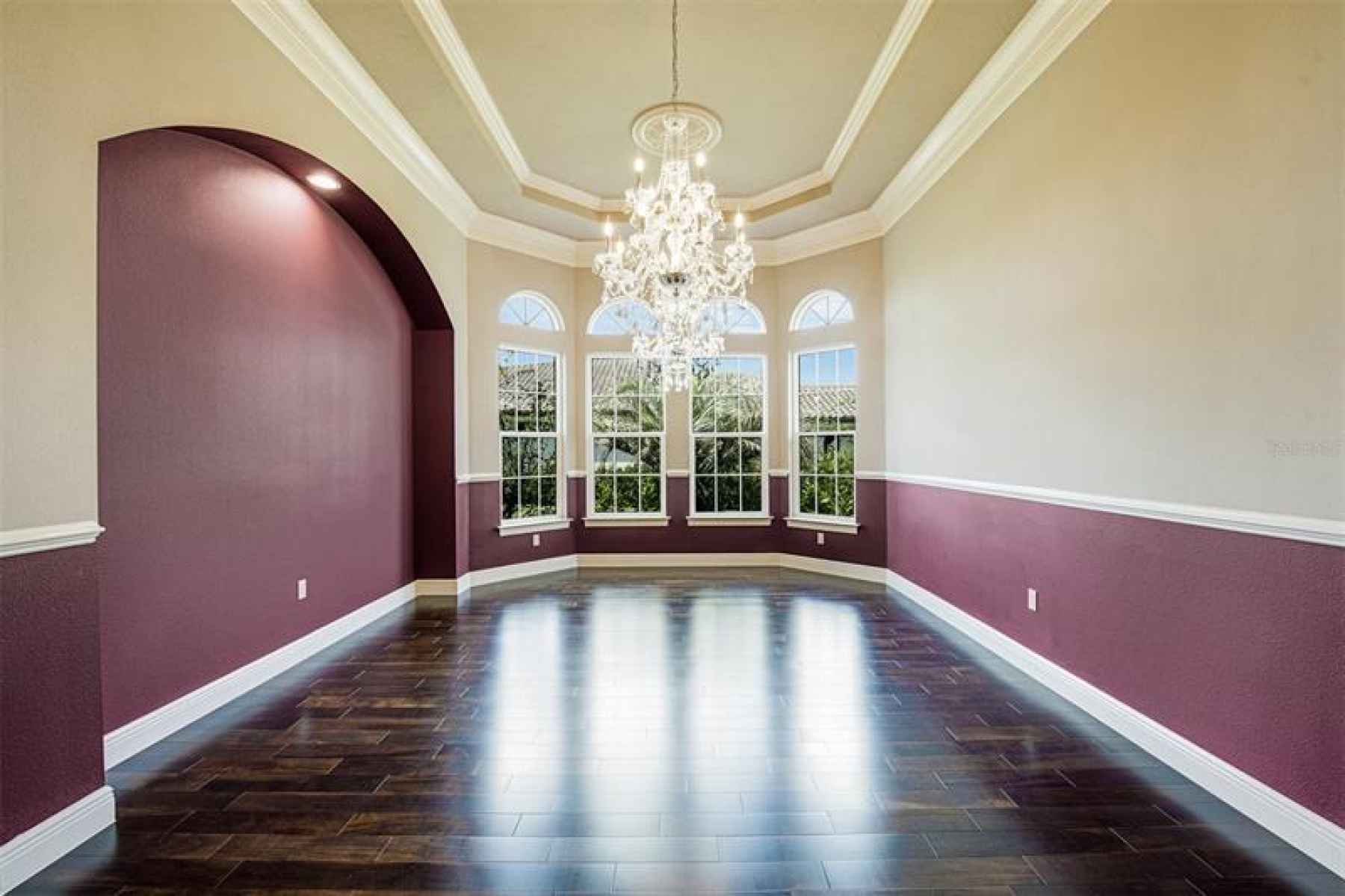 Dining room with bay windows, tray ceilings, and chandeliers