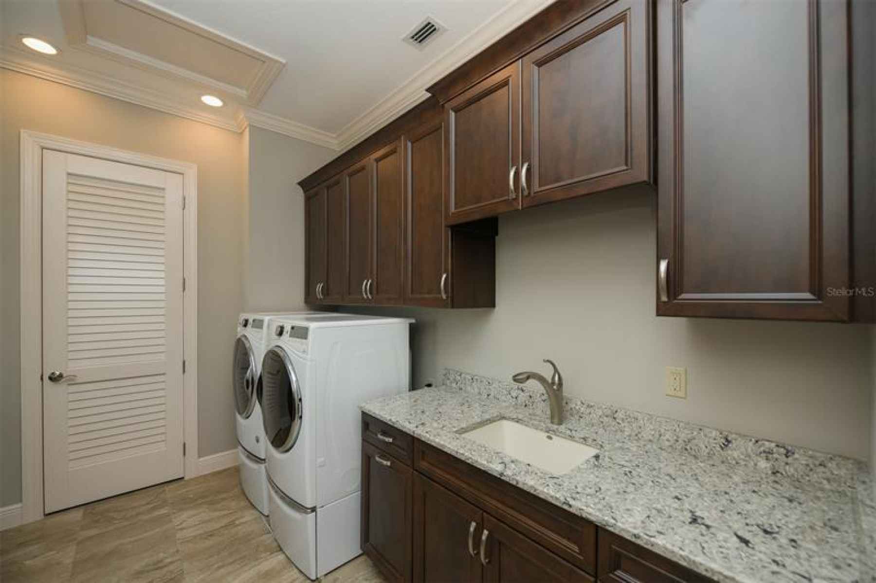 Laundry room with utility sink, folding area, and storage room