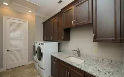 Laundry room with utility sink, folding area, and storage room
