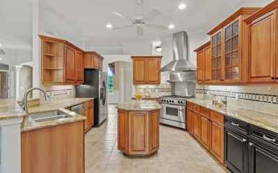 Kitchen has gas range, wood cabinetry, granite counters.