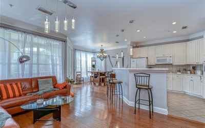 Neutral paint, high ceilings, crown molding, and rich wood flooring flow throughout the living and d
