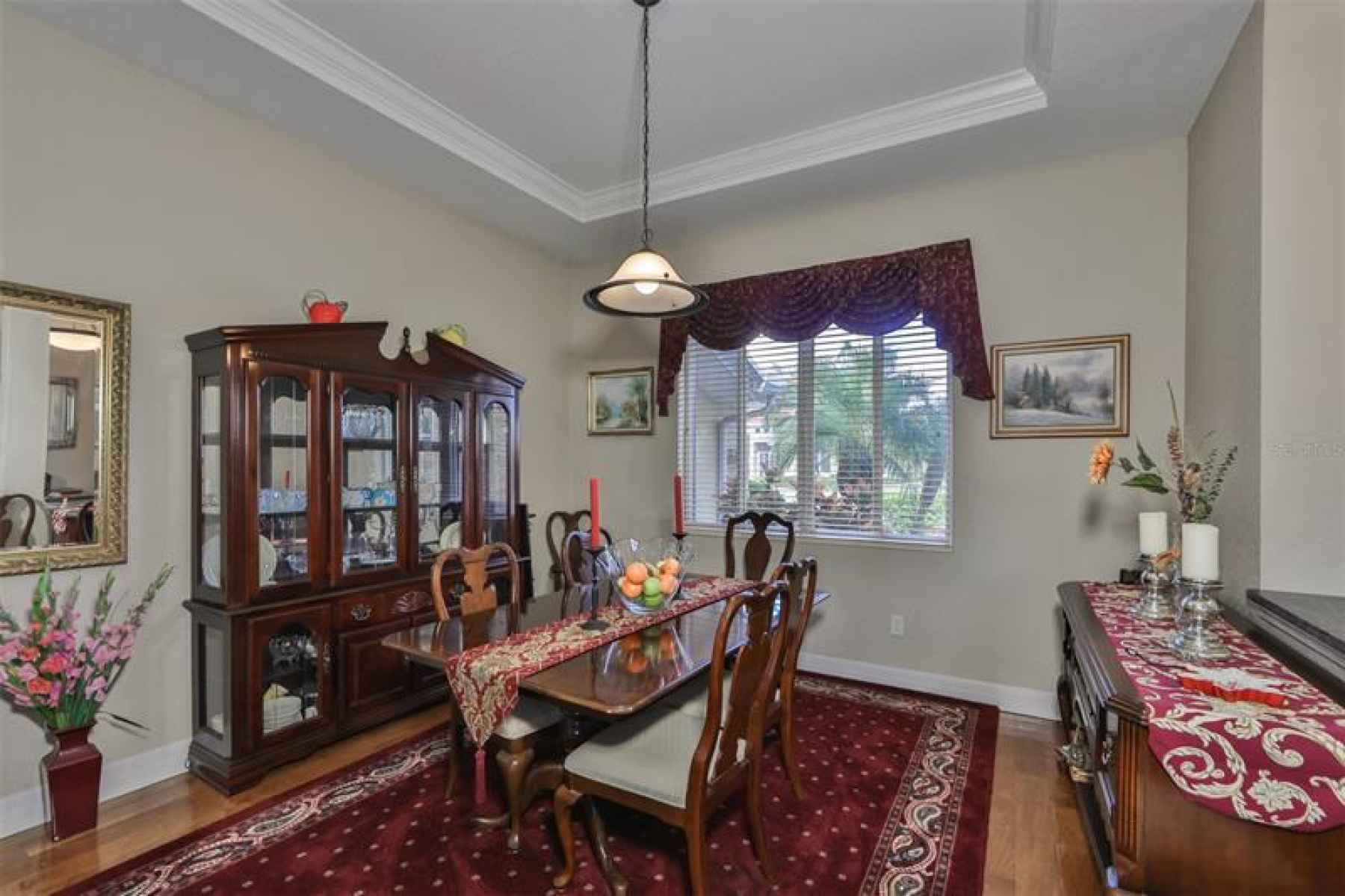 Formal dining room and real wood floor and tray ceiling.