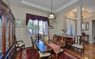 Formal dining room with tray ceiling located neighbors the grand foyer with extended ceiling height.