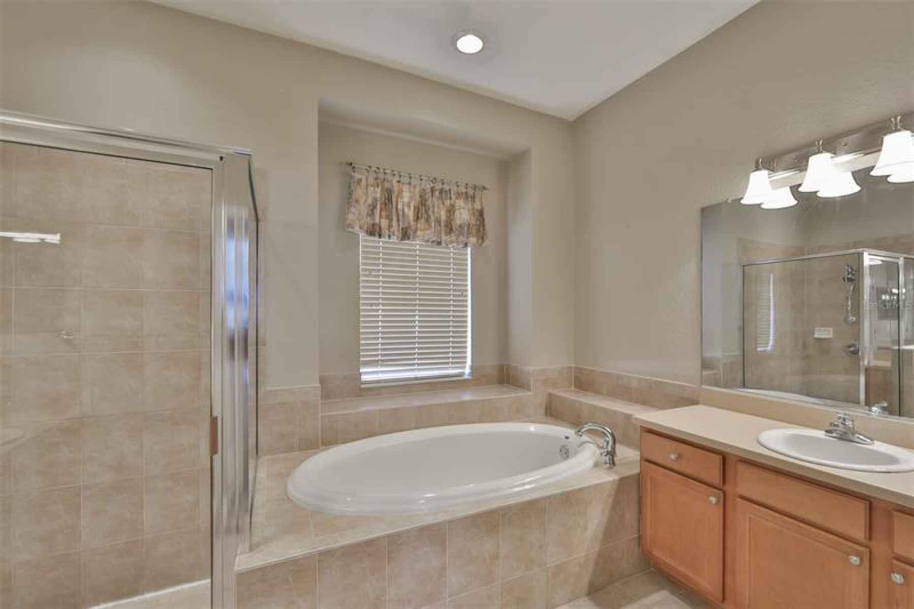 Impressive master bath with valuted ceilings, soaking tub, dual vanities and walk-in shower.