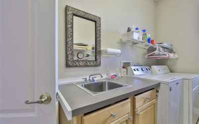 Private laundry room with sink and storage also includes garage door entrance.