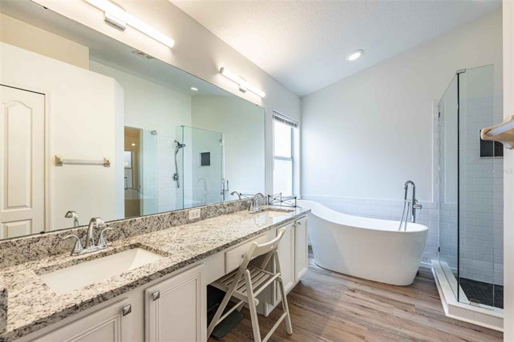 Newly remodeled master bath has granite counters with dual sinks, a soaking tub, separate shower and