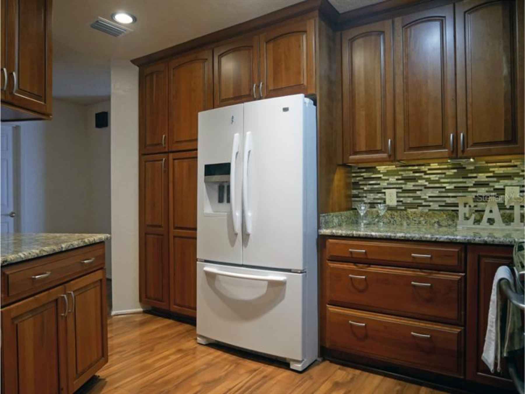 Ample amount of cabinetry, pantry on the left side of refrigerator with pull outs