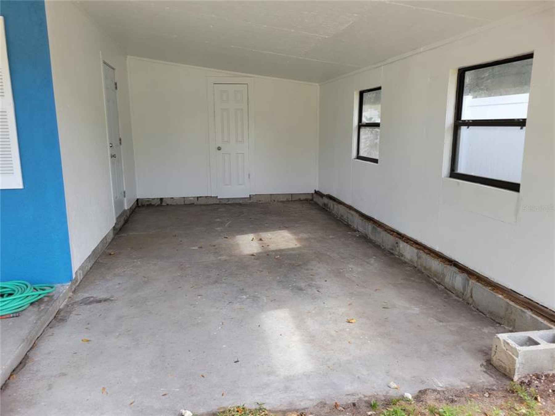 Carport with entrance to kitchen and laundry room and storage at the back