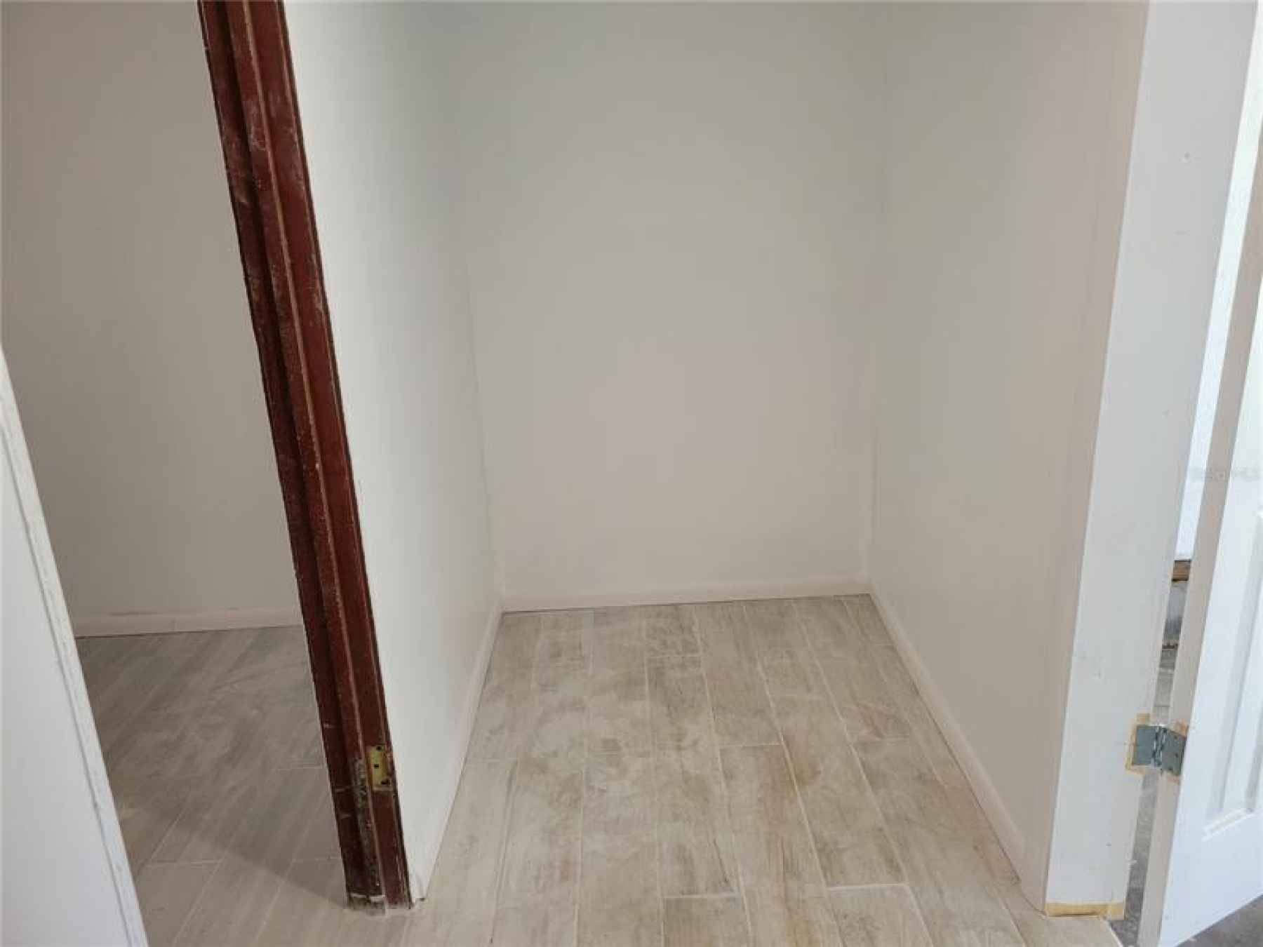 storage area in front of laundry room   combines space is  11 x 9 and has porcelain plank flooring