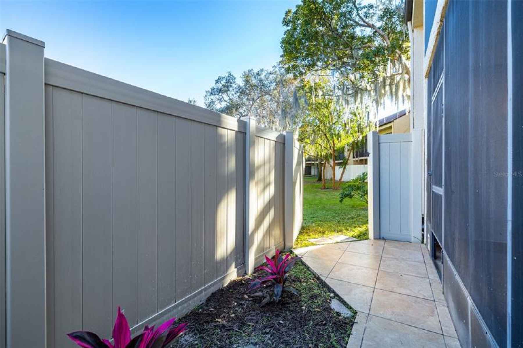 Paved Side Yard with Vinyl Fencing and Gate to Courtyard