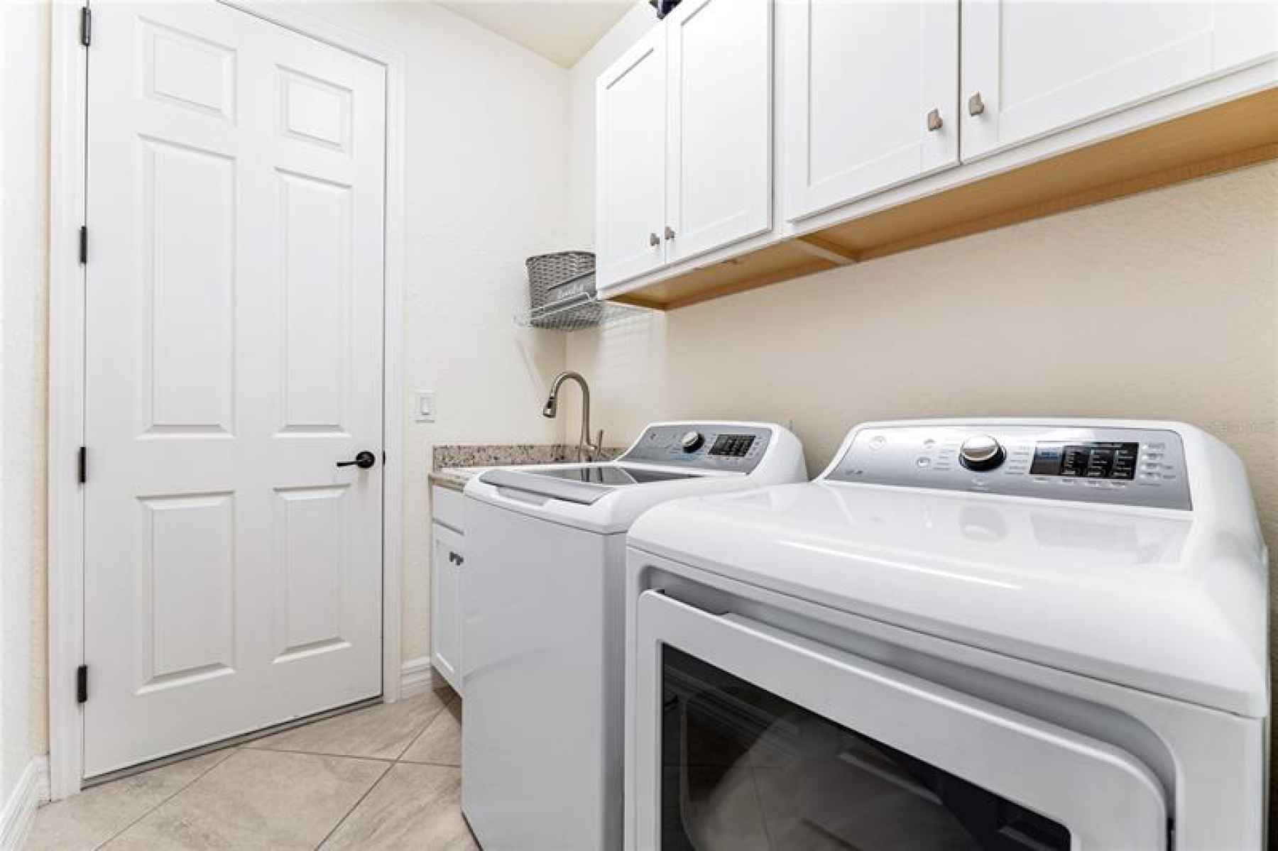 Laundry room with utility sink and garage access.