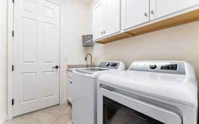 Laundry room with utility sink and garage access.