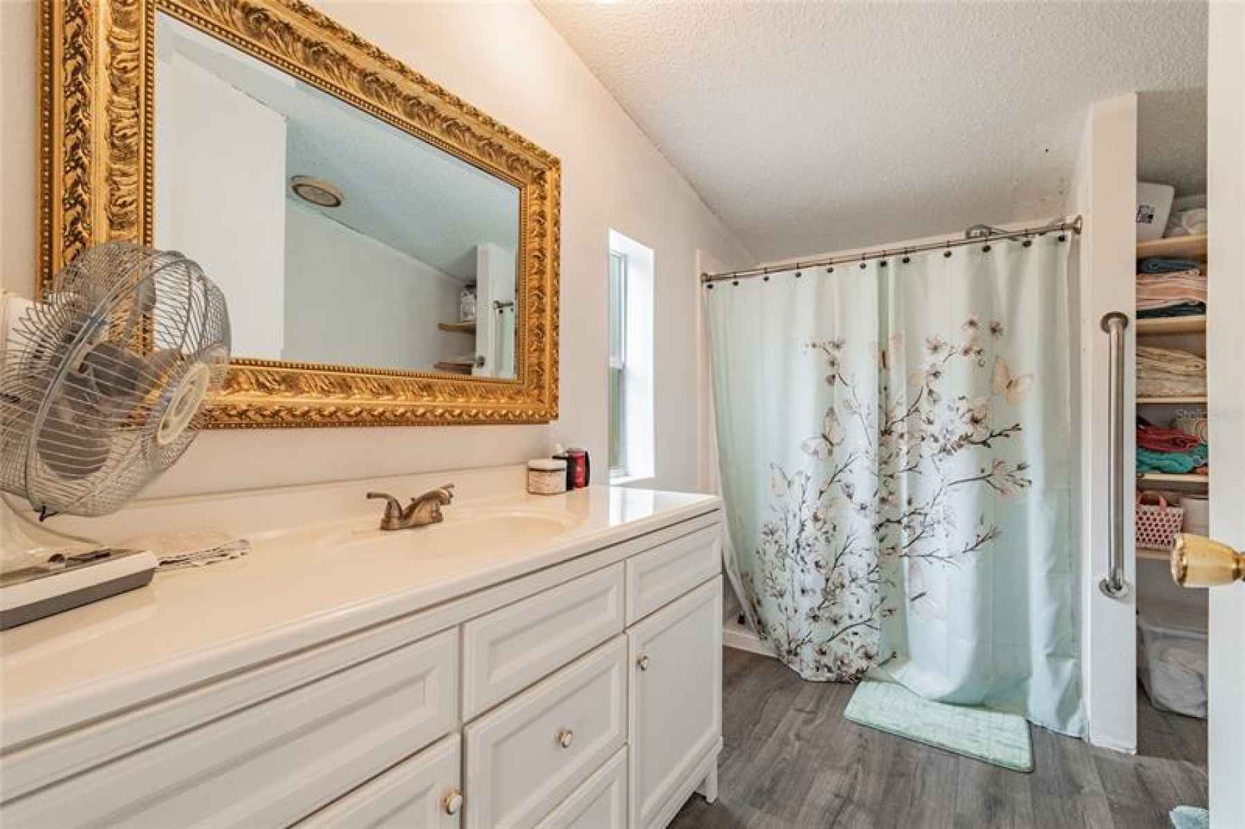 Master bedroom with updated vanity and cabinets.  Grab bar for the shower.