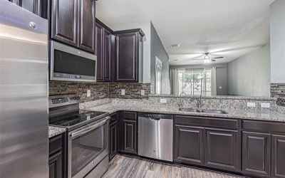 This large kitchen offers plenty of cabinet space, granite countertops, double sink, and stainless s