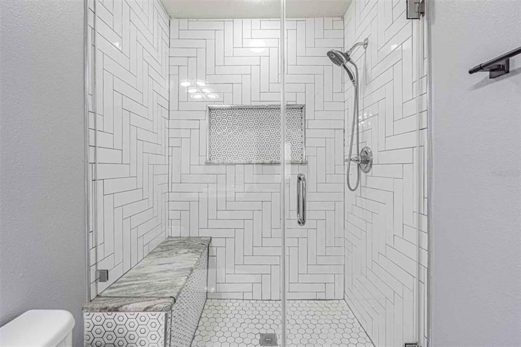 Built in shower bench and updated tiles give the shower a fresh clean look.