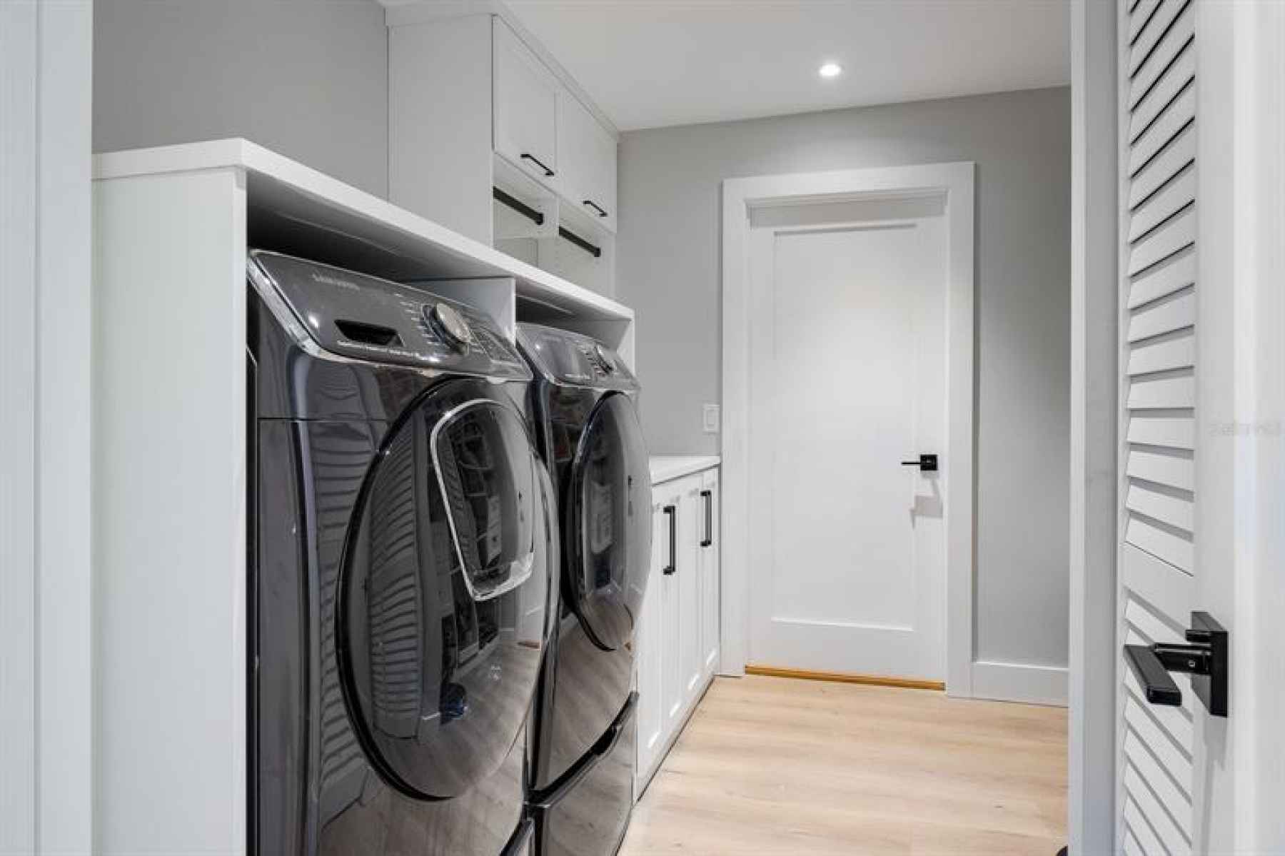 Huge laundry room with folding center, and plenty of storage for utility items and extra kitchen war